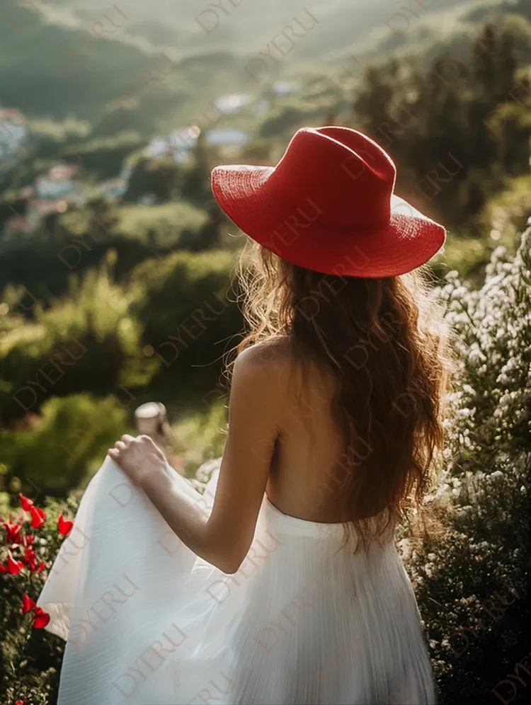 Mulher jovem de costas com vestido branco e chapéu vermelho em paisagem natural ao entardecer
